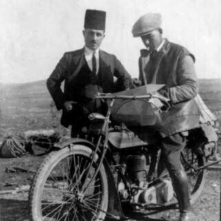Two men with vintage motorcycle and map