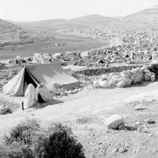 RW-Fawwar-2(H), A general view of tents in Fawwar Camp before shelters were provided to house nearly 5.000 Palestine refugees. It is situated in an isolated and barren region in the occupied West Bank of Jordan near Hebron. Fawwar is one of the 20 camps in the West Bank which provides shelter and some protection against the extreme heat and cold, to more than a quarter of a million Palestine refugees. Since the outbreak of hostilities in June 1967, the population of this camp was reduced by almost 50% because many of the Arab refugees fled to east Jordan. © 1950s UNRWA Photo